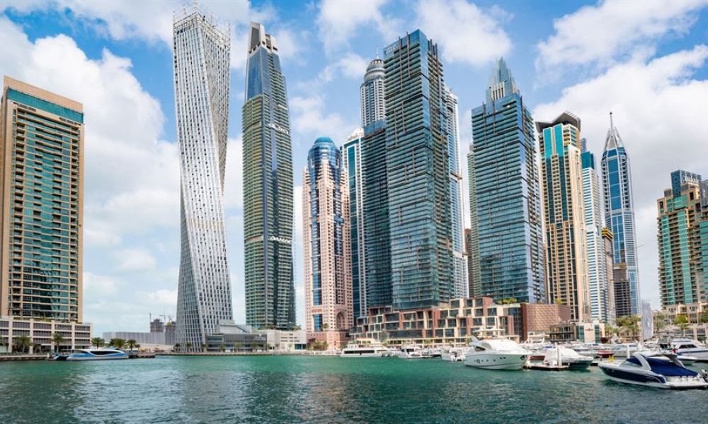 What Makes Uae National Day Long Weekend Best Time To Marry | What Makes Uae National Day Long Weekend Best Time To Marry ? | The United Arab Emirates Celebrates Their National Day On The 2Nd Of December Every Year. On February 10, 1972, The Seventh Emirate, Ras Al Khaimah, Was Admitted To The Federation, Becoming It The Last Emirate(State) To Do So. The image features Dubai's Marina with impressive skyscrapers under a partly cloudy sky. Luxury yachts float in the tranquil waters, symbolizing the vibrancy of life in this spectacular city. The iconic Cayan Tower stands out among the modern architecture, showcasing Dubai’s innovative designs while reflecting both glass and steel elements.