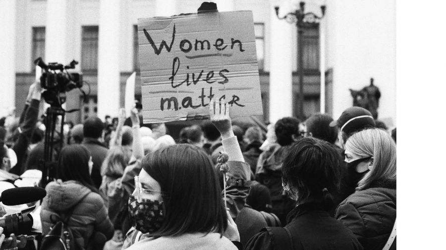 A cheerful couple standing together in a beautiful setting, symbolizing love and happiness on their wedding day. The image captures joyful moments of celebration with guests around them, showcasing various wedding elements such as decorations and cake, all set against the backdrop of stunning Dubai architecture.