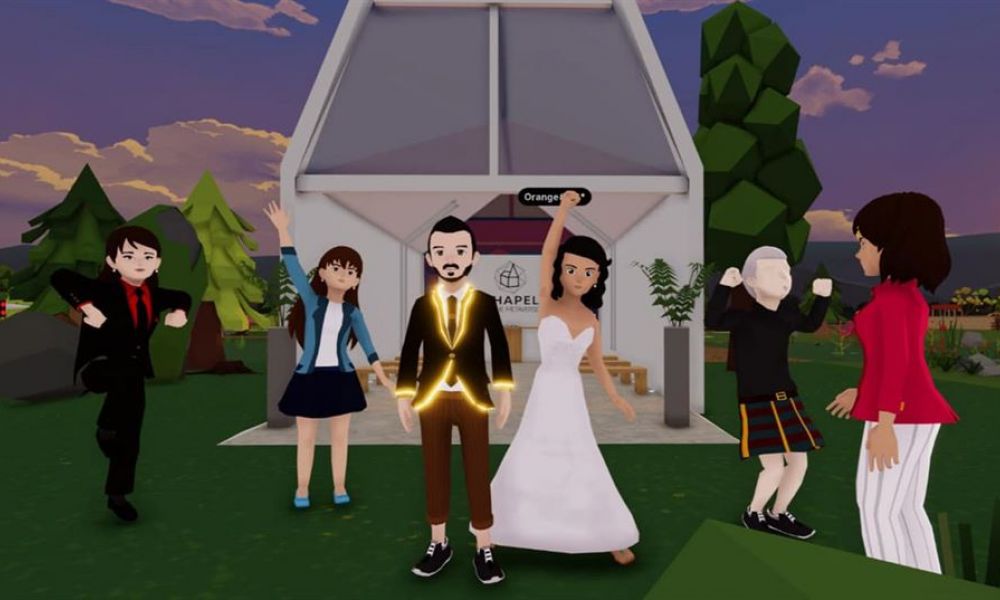 Uae First Metaverse Wedding | Be Ready: Uae’s First Metaverse Wedding Is Happening Tomorrow | Florian Ughetto And Liz Nunez Will Be The First Couple In The United Arab Emirates To Marry In The Metaverse On May 19. Decentraland Will Host The Ceremony, Which Will Be Attended By The Couple'S Close Family And Friends. An animated scene of a joyful wedding celebration in front of a modern chapel during sunset. A groom in a glowing suit and bride in a white gown stand together surrounded by happy animated characters celebrating their special day with raised arms. The backdrop features rolling hills and trees creating a festive atmosphere suitable for weddings in Dubai.