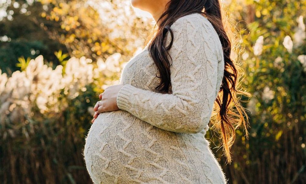 What Should I Do If I Get Pregnant Before Marriage Dd860D81 | What Should I Do If I Get Pregnant Before Marriage | Not Long Ago, Pregnancy Before Marriage Was Strictly Prohibited In The Uae; Which Simply Meant Getting Married While Being Pregnant Was A Punishable Offense. However With That Said, There Is Definitely Light At The End Of The Tunnel With The New Laws. A cheerful pregnant woman stands outdoors surrounded by lush greenery. Sunlight bathes her in warmth as she shows off her baby bump dressed in a cozy sweater. Her long hair flows down, complementing her serene smile against the soft-focus background of plants and leaves. This scene depicts tranquility and excitement, perfect for maternity photography.