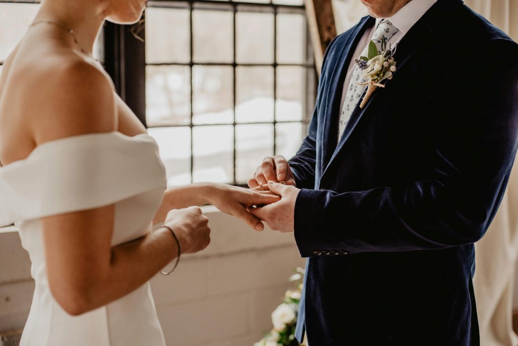 Couple exchanging rings during a simple marriage ceremony without guests