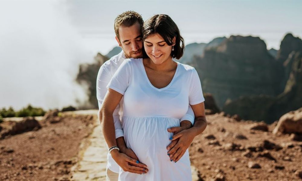The image shows a happy couple celebrating their wedding day in an elegant setting of Dubai. They are surrounded by friends and family enjoying the moment. The picturesque backdrop highlights iconic Dubai landmarks, flowers adorning the space, and beautiful decorations creating a joyful atmosphere. The couple radiates happiness as they take their vows or hold hands during their ceremony, symbolizing love and commitment while capturing their memorable day.