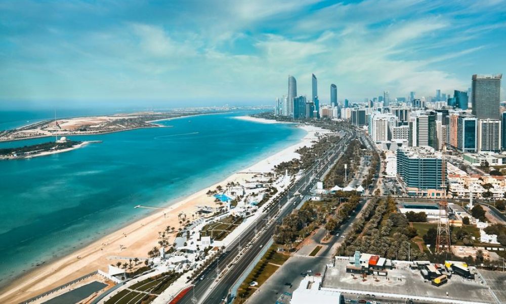 43Fb9146 | The Ruler Of Abu Dhabi Signs An Order Permitting Non-Muslims To Marry And Divorce Under Civil Law | The United Arab Emirates Has Made Yet Another Bold Move To Keep Its Competitive Edge As A Regional Business Powerhouse Which Is Changing Its Marriage Laws. Its A Known Fact That Its Personal Status Laws On Marriage And Divorce Were Previously Based On Islamic Sharia Principles. However The New Marriage Laws Seem To Be In Favor Of Many. The image captures a breathtaking aerial view of Abu Dhabi showcasing modern skyscrapers against the turquoise Arabian Gulf. The beautiful coastline is lined with sandy beaches bordered by clear blue waters and vibrant palm trees. This enchanting scene perfectly blends natural beauty with urban setting, reflecting what makes Abu Dhabi unique as a wedding destination. Perfect for couples looking to get married surrounded by stunning landscapes and contemporary architecture.