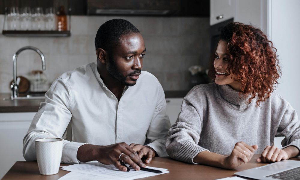 couple planning a wedding in Dubai without a fixed date using laptop and documents